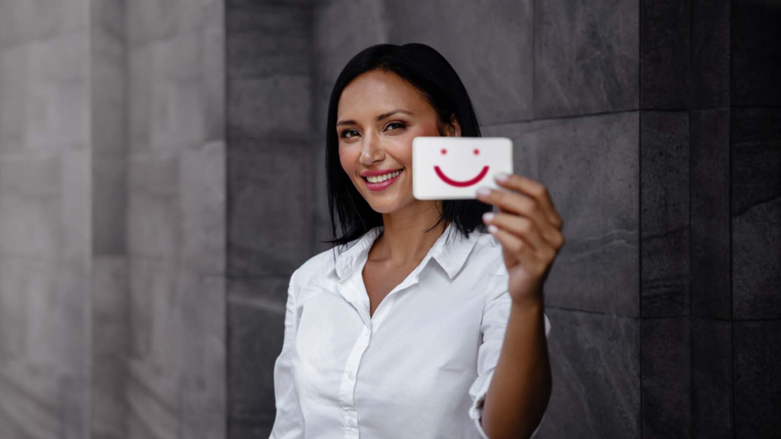 women holding a happy emoticon card
